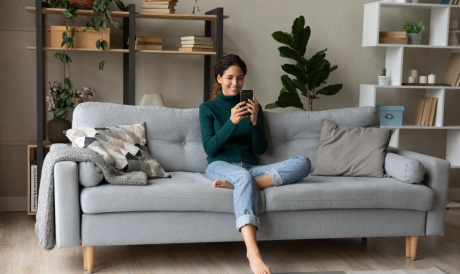 A person sitting on a couch looking at a phone